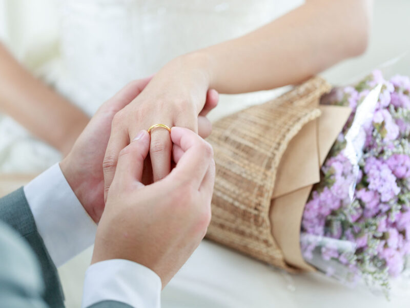 Hand of The groom wears a wedding ring to the bride.